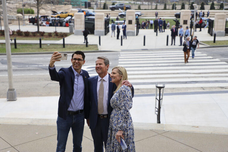 Rivian CEO R.J. Scaringe takes a selfie with Gov. Brian Kemp and First Lady Marty Kemp on “Rivian Day” at the state Capitol on March 1, 2023. Governor’s office photo