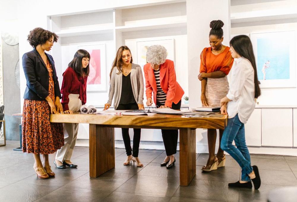 Women work at a table.