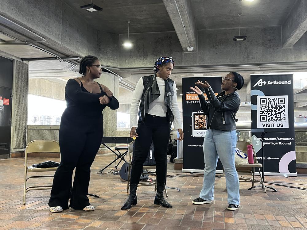 Zora Umeadi, Shakirah Demesier, and Asha Basha Duniadi perform a scene together for commuters at the College Park MARTA station on February 6, 2025.