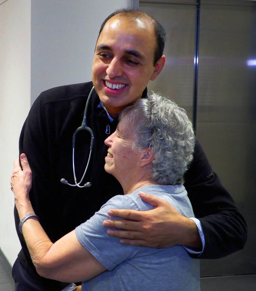 Susan Williams, a patient at the John B. Amos Cancer Center in Columbus, Georgia, hugs her physician, Dr. Mukesh Kumar, M.D. a hematologist and medical oncologist at the John B. Amos Cancer Center in Columbus, Georgia. Credit: Mike Haskey/Columbus Ledger-Enquirer