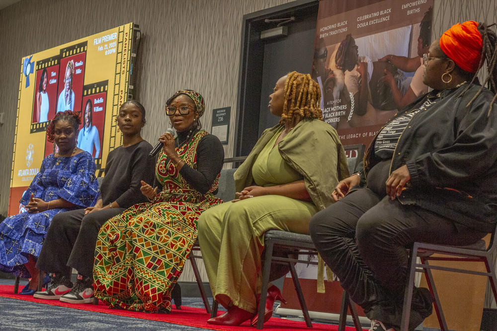 Doula Bashellia Williams, center, and nonprofit founder, Sekesa Berry, far left, sit with other members of the Atlanta Doula Collective featured in "Cradled in Culture: Reclaiming the Legacy of Black Doula Care," during the documentary screening on Feb. 21, 2025, in Atlanta.