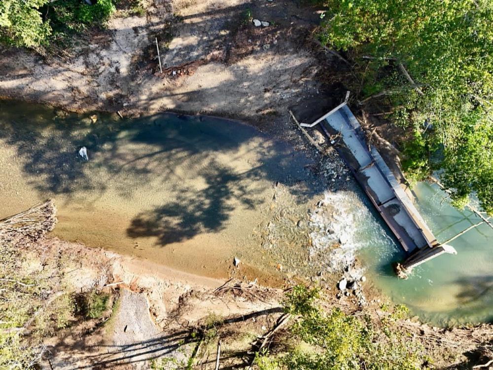 Aerial photo of a bridge flipped over in Old Fort, NC from Hurricane Helene