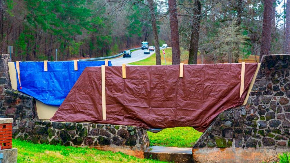 The stone gate entrance sign that welcomed people to Fort Moore is covered with tarps March 5, 2025, now that the U.S. Army post next to Columbus has been renamed back to Fort Benning. This entrance is on Ft. Benning Road. 