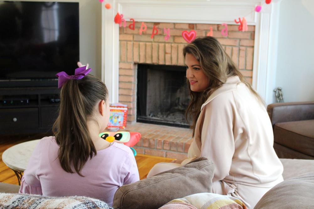 Megan Planovsky watches her daughter, Lydia Dobbs, play with a toy in their home.