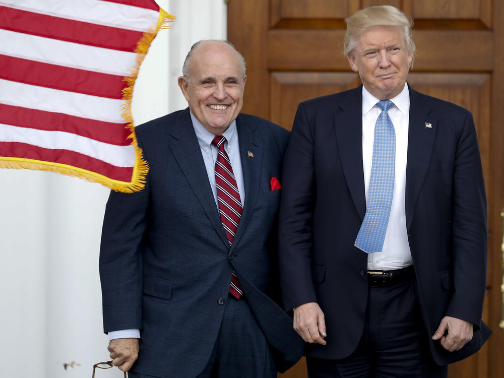 Rudy Giuliani is seen here with Donald Trump shortly after Trump's election victory in 2016. Federal authorities raided Giuliani's apartment Wednesday, the former New York City mayor's attorney said.