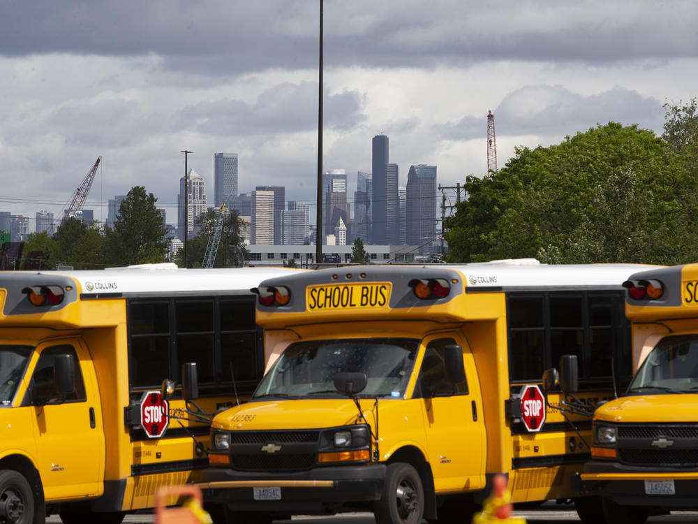 School buses sit idle in a Seattle bus yard. On July 2, Seattle Public Schools announced it is planning to resume some in-person learning in the new school year.
