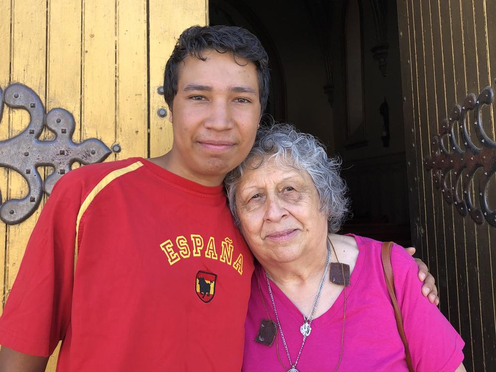 Matthias Bowie and his grandmother Lynda Martinez stand outside the Shrine of Our Lady of Lourdes after a recent morning mass in Ohkay Owingeh Pueblo.