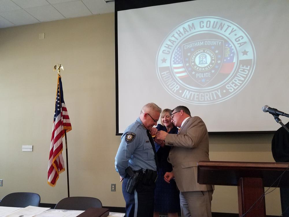 Chatham County Police Chief Jeff Hadley gets his new badge from County Manager Lee Smith.