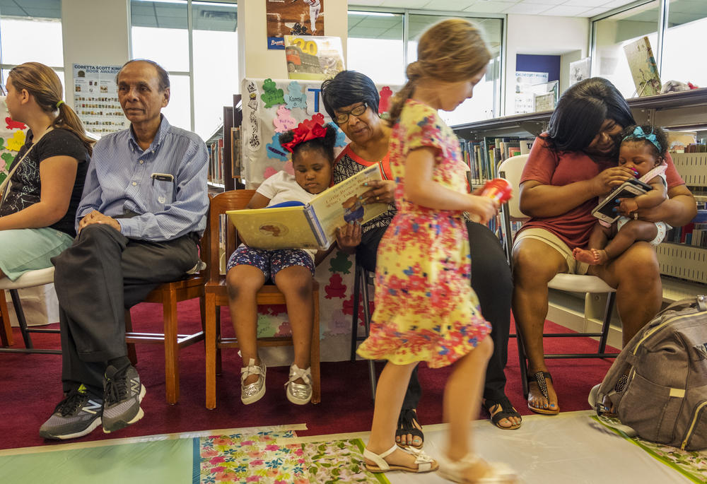 Johnnie Prater, center, reads to her granddaughter at the Riverside Library in Macon Friday. 