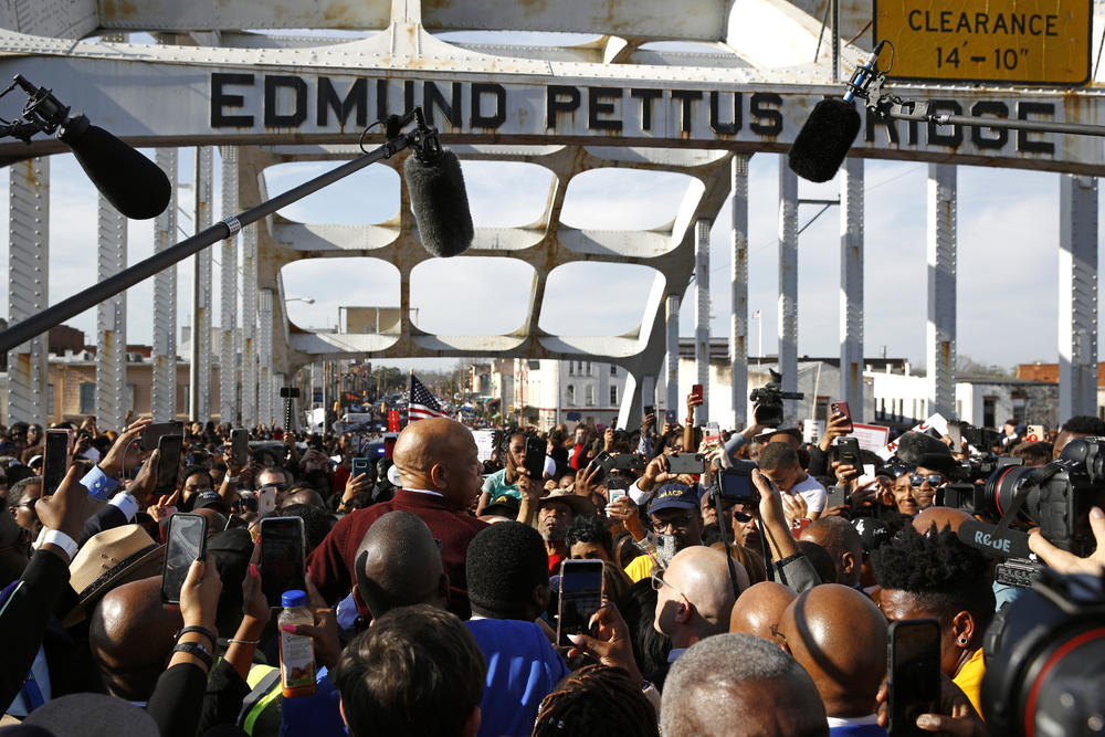 Rep. John Lewis, D-Ga., center in red, addresses a crowd on the Edmund Pettus Bridge in Selma, Ala., Sunday, March 1, 2020, during a commemoration of the 55th anniversary of 