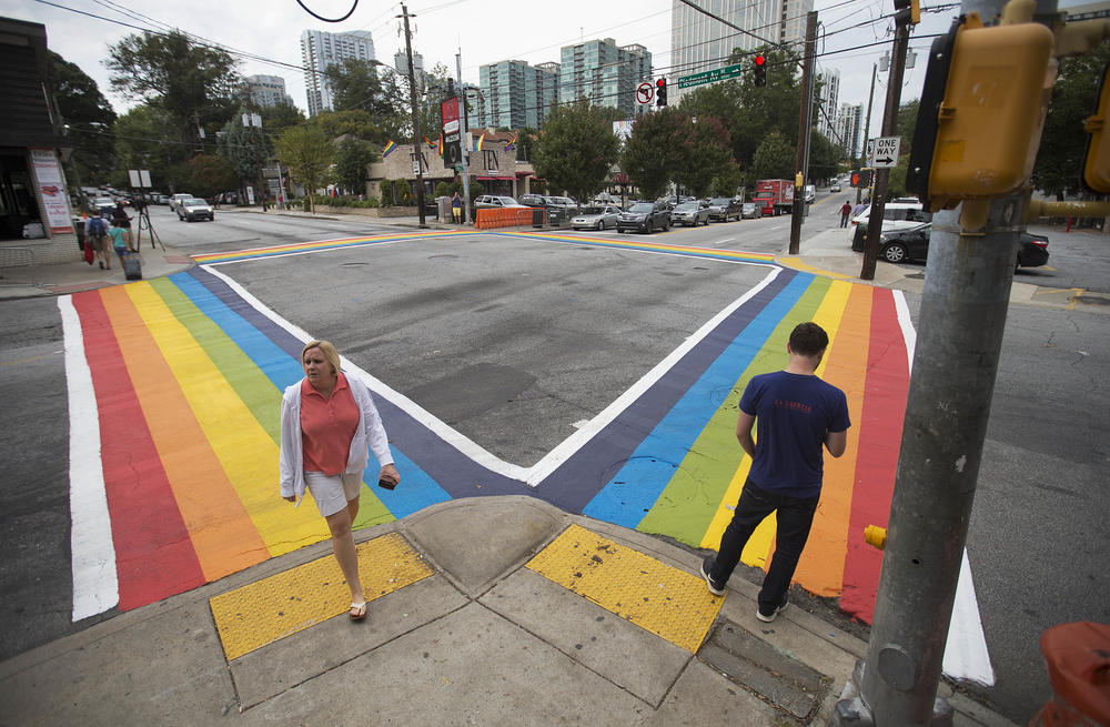 Pedestrians cross a rainbow painted crosswalk in midtown to commemorate the annual Atlanta Pride Parade.