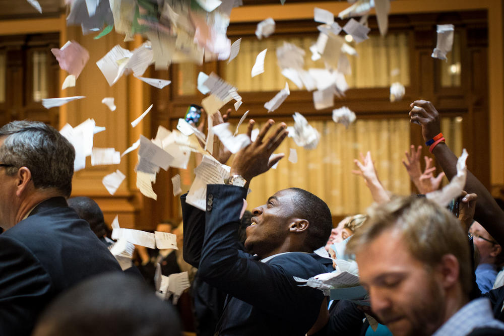 House members throw paper in the air to celebrate the end of the 2015 legislative session.