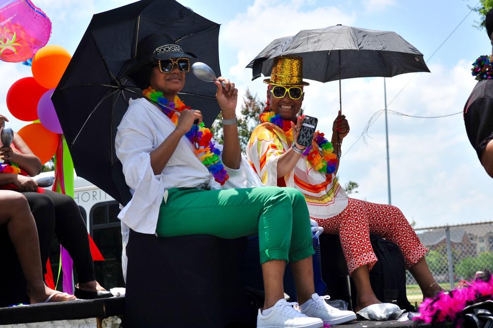 Two women celebrating the Juneteenth festival on one of the colorful floats in the parade. 