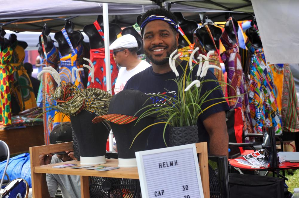 Harlam Duru is a vendor at the fesitval. His company's name is Healm, they do headwraps and create festive hats. 