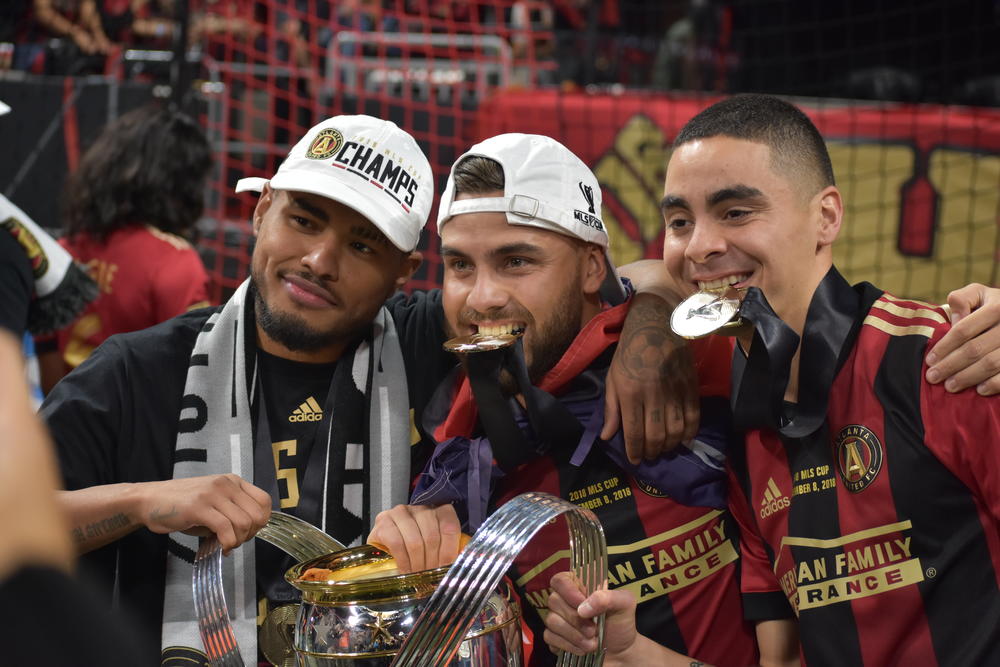 (left to right) Josef Martinez, Hector Villalba, and Miguel Almiron pose with the championship trophy.