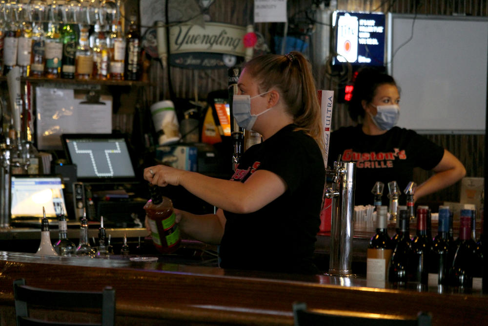 Ashley Mackay serves a customer at Guston's Bar and Grille in Woodstock on Monday, April 27, 2020.