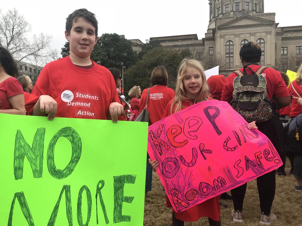 Ben Trussell, 10, and Chloe Trussell, 7, both of Kennesaw, Georgia, hold signs at the Moms Demand Action for Gun Sense rally. 