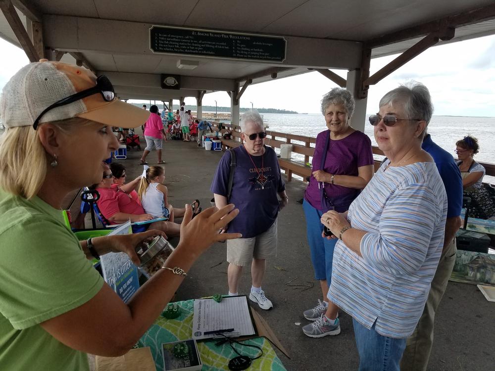 Lea King-Badyna explains to passersby why her group, Keep Golden Isles Beautiful, wants to keep cigarette butts off the beach. She's also handing out portable ashtrays.