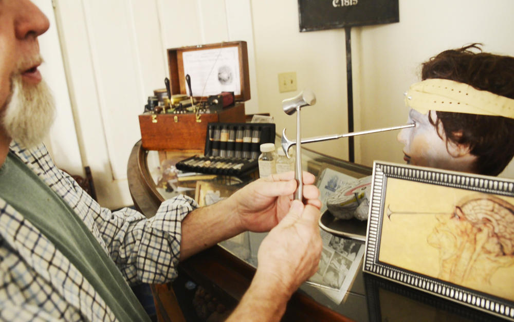 Edwin Atkins demonstrates the use of lobotomy instruments with tools in his personal collection of Central State Hospital artifacts. 