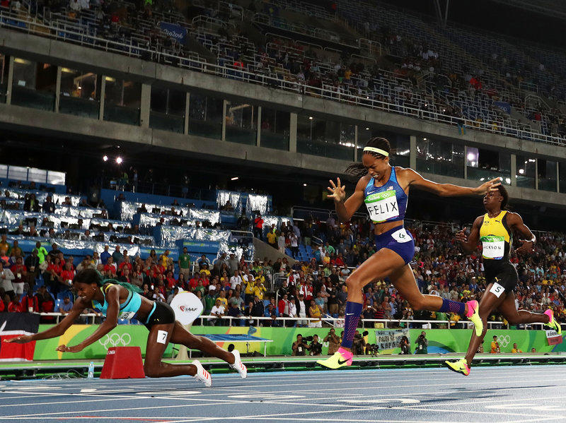 Shaunae Miller of the Bahamas (left) dives over the finish line to win the gold medal in front of Allyson Felix of the U.S., in the women's 400-meter race. Felix won silver; Shericka Jackson of Jamaica (right) won bronze.