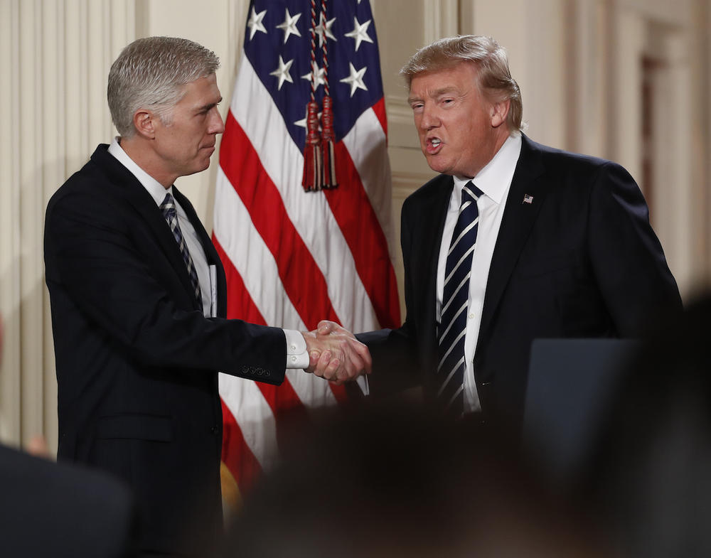 Judge Neil Gorsuch shakes hands with President Donald Trump as he is announced as Trump's choice for Supreme Court Justice during a televised address from the East Room of the White House in Washington, Tuesday, Jan. 31, 2017. 