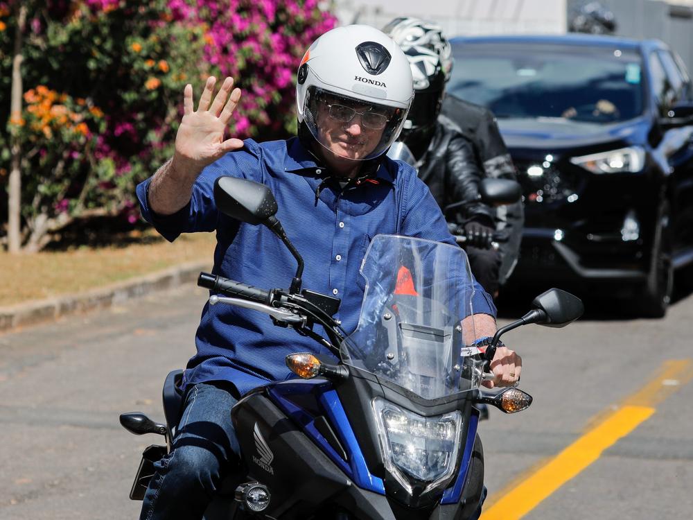 Brazilian President Jair Bolsonaro takes a ride on a motorcycle Saturday in Brasilia after he announced he tested negative for the coronavirus. He had tested positive earlier this month.