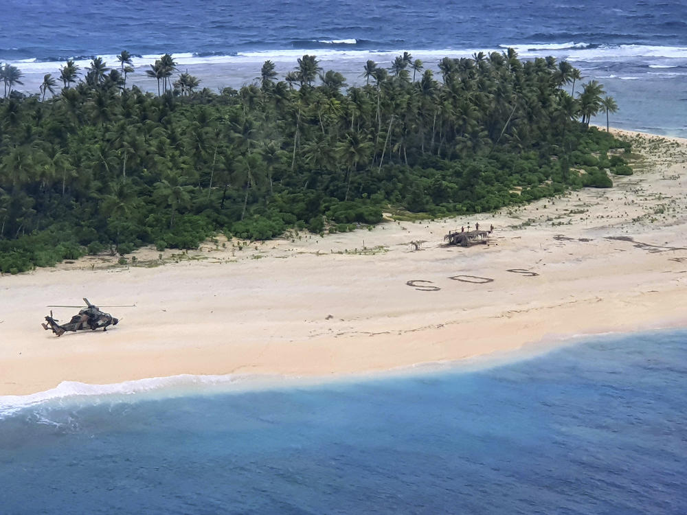 In this photo provided by the Australian Defence Force, an Australian Army helicopter lands on Pikelot Island in the Federated States of Micronesia to rescue three stranded mariners who had been missing for nearly three days.