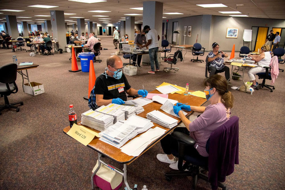 Election workers Jeff and Lori Lutzka process absentee ballots at Milwaukee's 