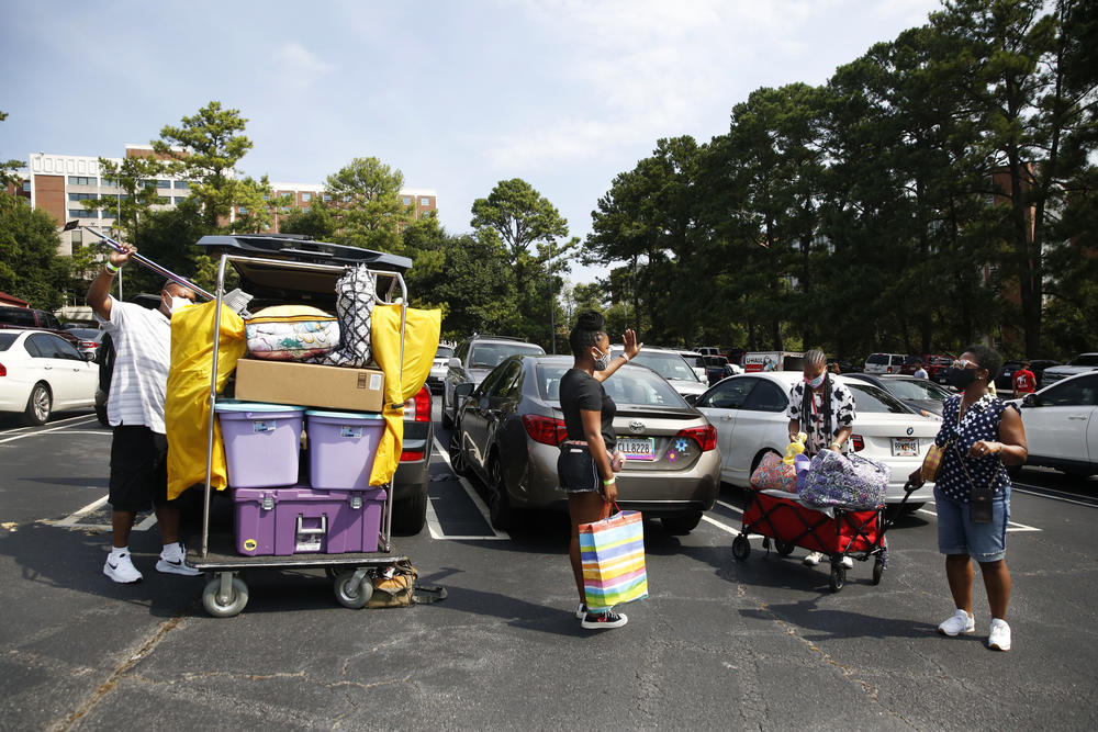 The Lawrence family moves their youngest daughter, Kelsey (center), into her new dorm room. The university allowed each student only two move-in helpers, leaving mom Vanessa Lawrence (far right) to wait outside.