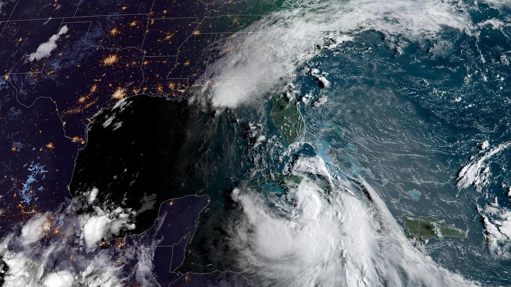 Tropical Storm Marco (top) is weakening as it nears the Gulf Coast in Louisiana, while Tropical Storm Laura (bottom right) — currently just south of Cuba — is on track to become a hurricane.