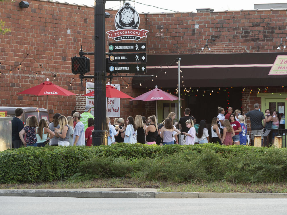 People line up outside to order food from a taco restaurant in Tuscaloosa, Ala. Social media images of crowds outside bars drew scrutiny last weekend in the city, which is home to the University of Alabama.