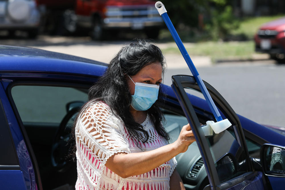 Volunteer Frances Acuña practices attaching a specialized sensor to her car door. It will measure both temperature and humidity.