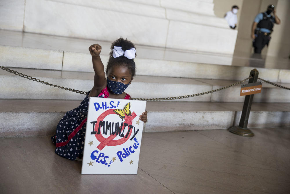 Laylah Pope, 5, poses at the foot of Lincoln's statue with her sign. She is from Detroit and was with her grandmother.