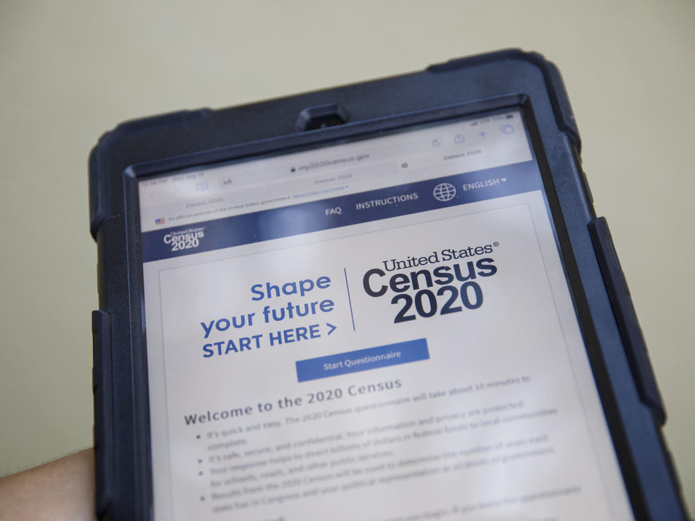 A volunteer in Los Angeles holds a computer tablet displaying the online questionnaire for the 2020 census in August.