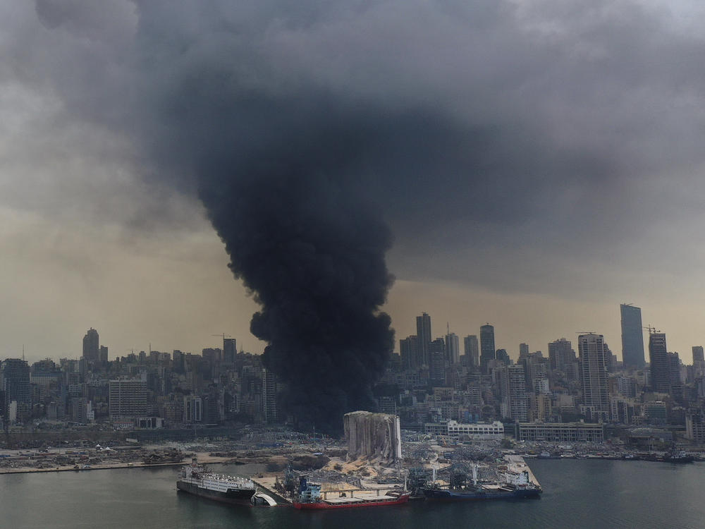 A column of black smoke rises from a fire Thursday at a warehouse at Beirut's port. A Lebanese official said the fire is under control, according to local media.