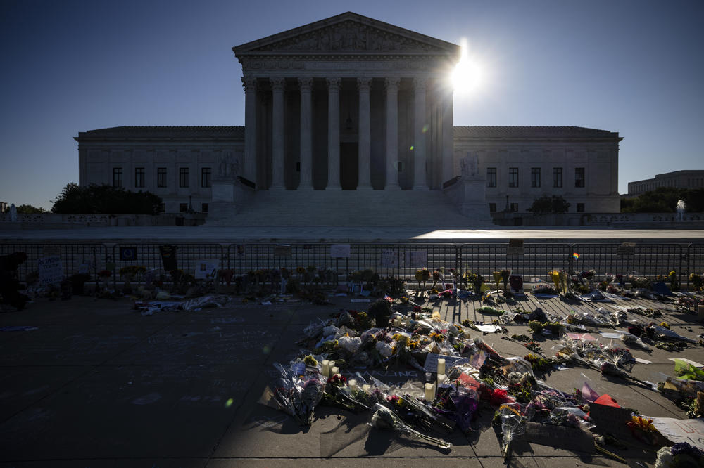 People place flowers at a makeshift memorial to honor Supreme Court Justice Ruth Bader Ginsburg in front of the Supreme Court on Sunday.