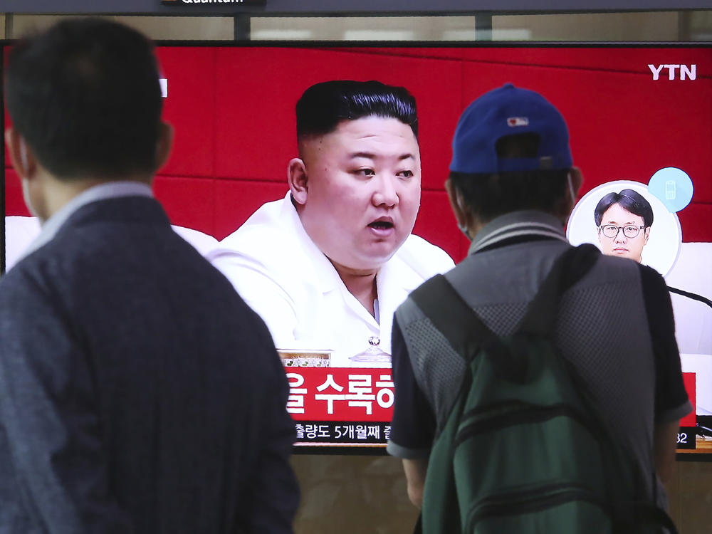 People at the Seoul Railway Station in Seoul watch a news program Friday showing a file image of North Korean leader Kim Jong Un, who said he was sorry over the killing of a South Korean fisheries official near the two countries' disputed sea boundary.