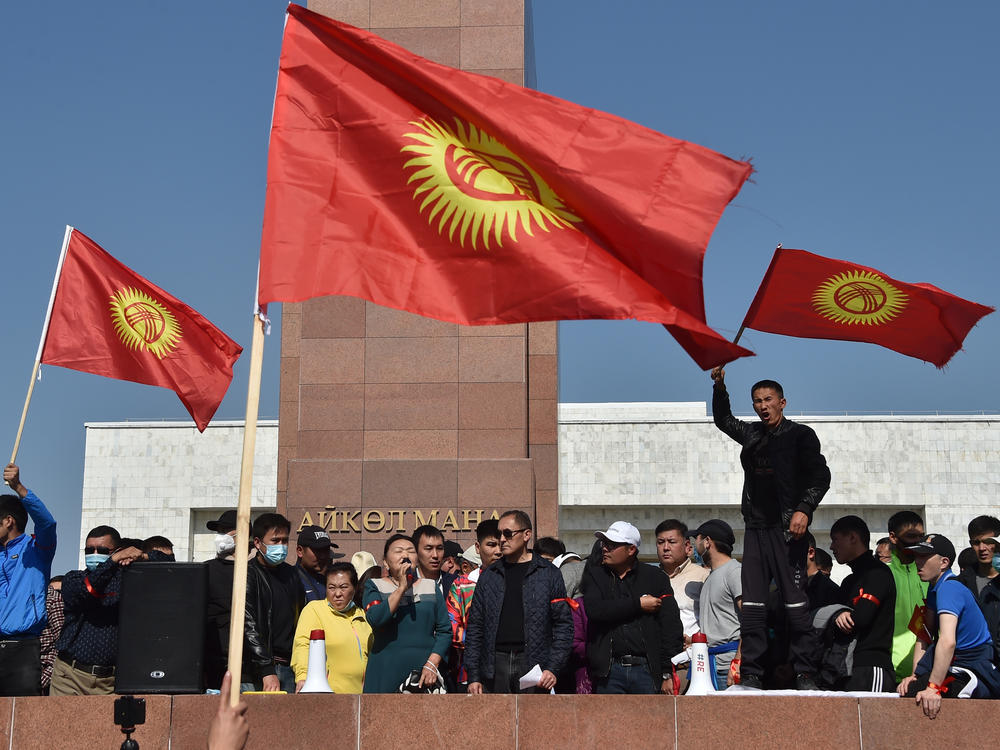 People protest beside the parliament building in Bishkek, which also houses the offices of Kyrgyzstan's president, during protests on Monday.