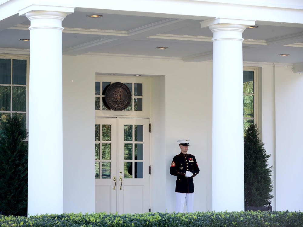 A U.S. Marine stands watch Wednesday outside the doors of the White House West Wing. According to the White House, President Trump was in the Oval Office on Wednesday afternoon, even as he continues to be monitored for COVID-19.