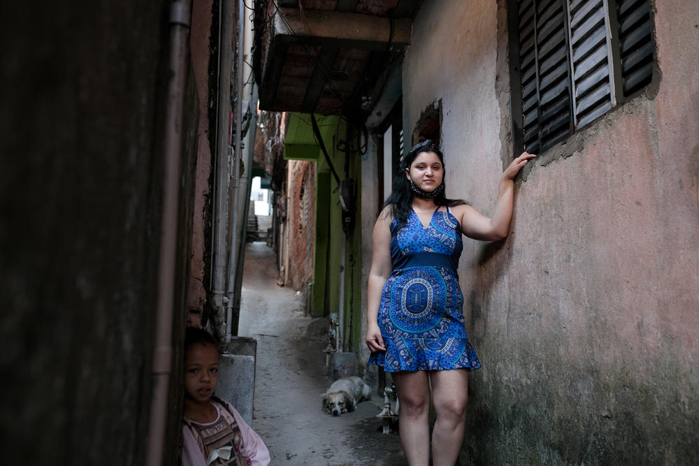 Jessica Fernandes de Andrade  outside her house in a favela in São Paulo, Brazil. She contracted the novel coronavirus and has recovered but still suffers from fatigue, which has kept her from working.