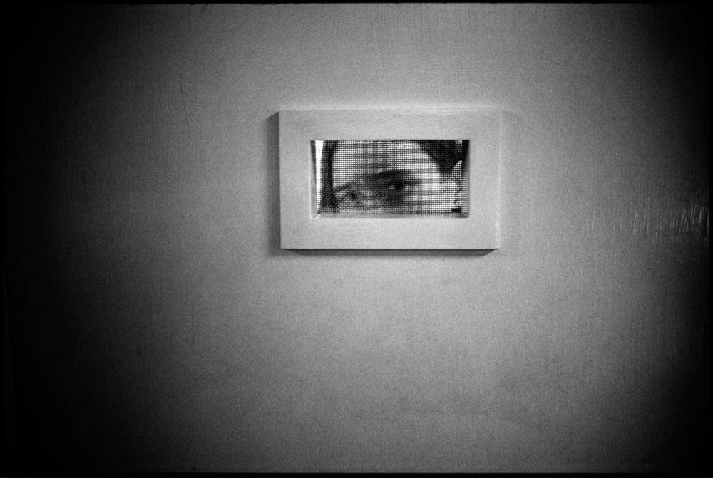 Tommie peeking out of her room, Ward 81, Oregon State Hospital. Salem, Oregon, 1976.