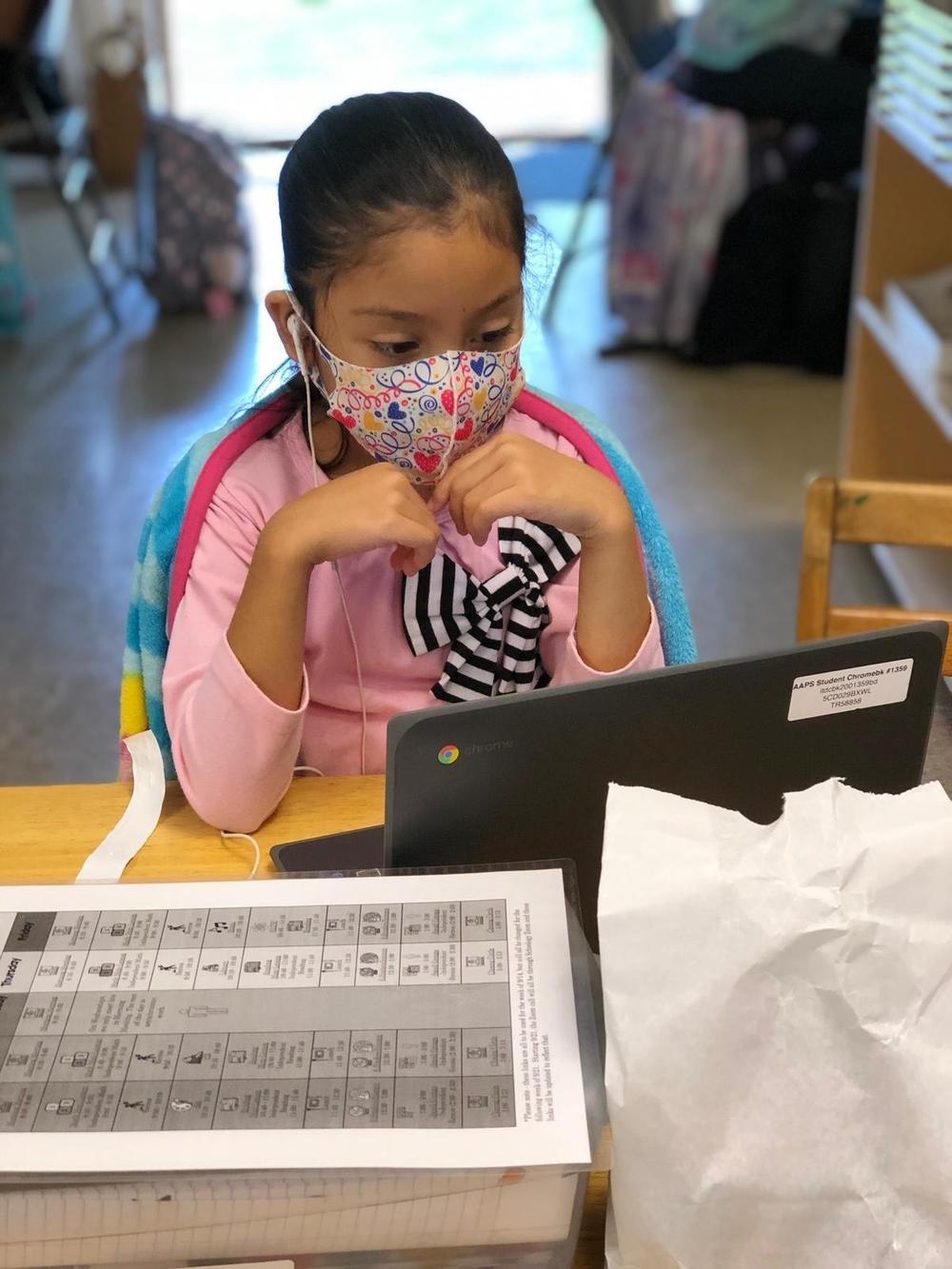 Angelique, a third grader, follows her afternoon virtual classes on an iPad at the Ann Arbor Community Learning Center, A learning hub helping the children of undocumented families attend to their virtual classes while their parents go to work.