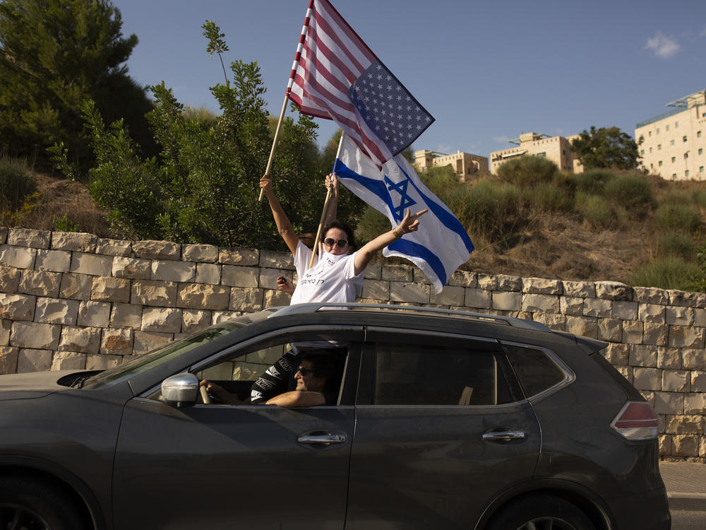 Supporters of President Trump wave U.S. and Israeli flags from a car last week headed for a rally outside the U.S. Embassy in Jerusalem.