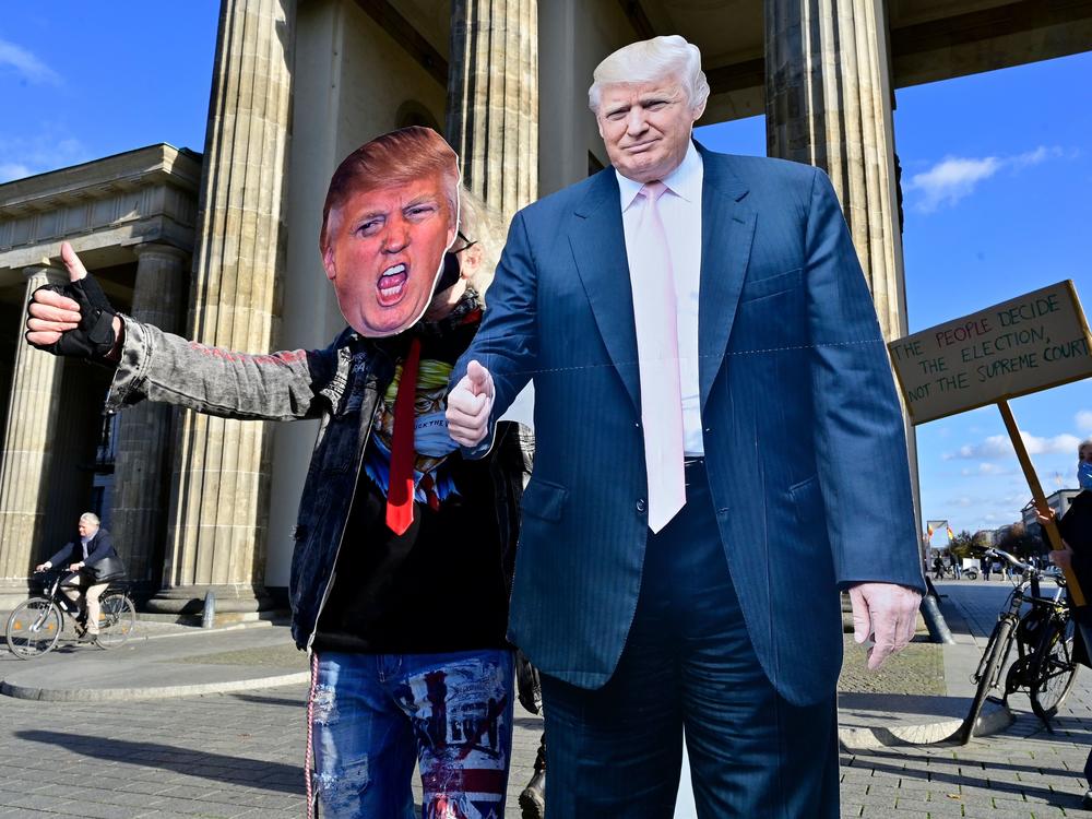 A supporter of President Trump poses with a cardboard-cutout likeness Wednesday in front of the Brandenburg Gate in Berlin.