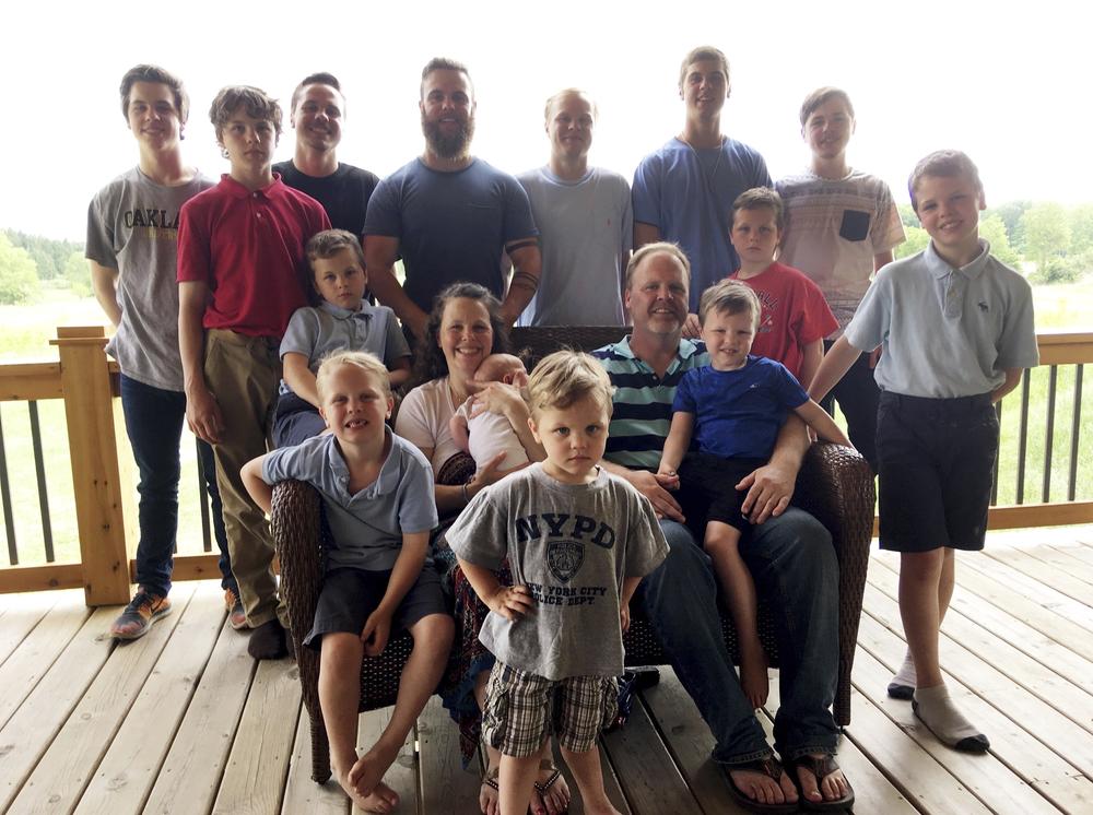 The Schwandt family poses for a photo in 2018 at their farm in Lakeview, Mich. Standing from left are Tommy, Calvin, Drew, Tyler, Zach, Brandon, Gabe, Vinny and Wesley. Seated, starting at upper left are Charlie, Luke, mother Kateri holding Finley, father Jay with Tucker and Francisco in the foreground.