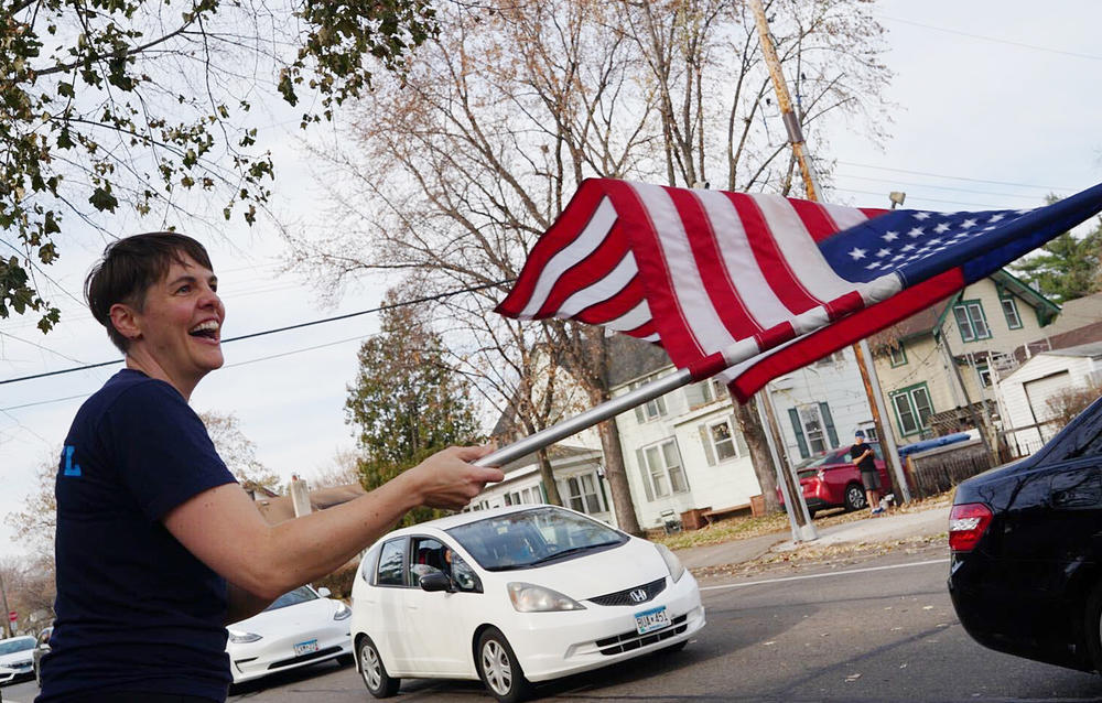 <strong>MINNEAPOLIS</strong>: Becky Kuehn waves a flag on the sidewalk to passing cars as she celebrates Joe Biden's victory in the presidential election in south Minneapolis.