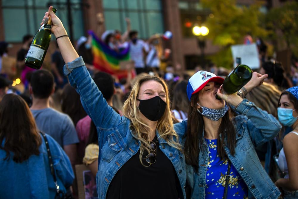 <strong>BOSTON</strong>: Two women celebrate Joe Biden's presidential victory, drinking bottles of champagne on Boylston Street.