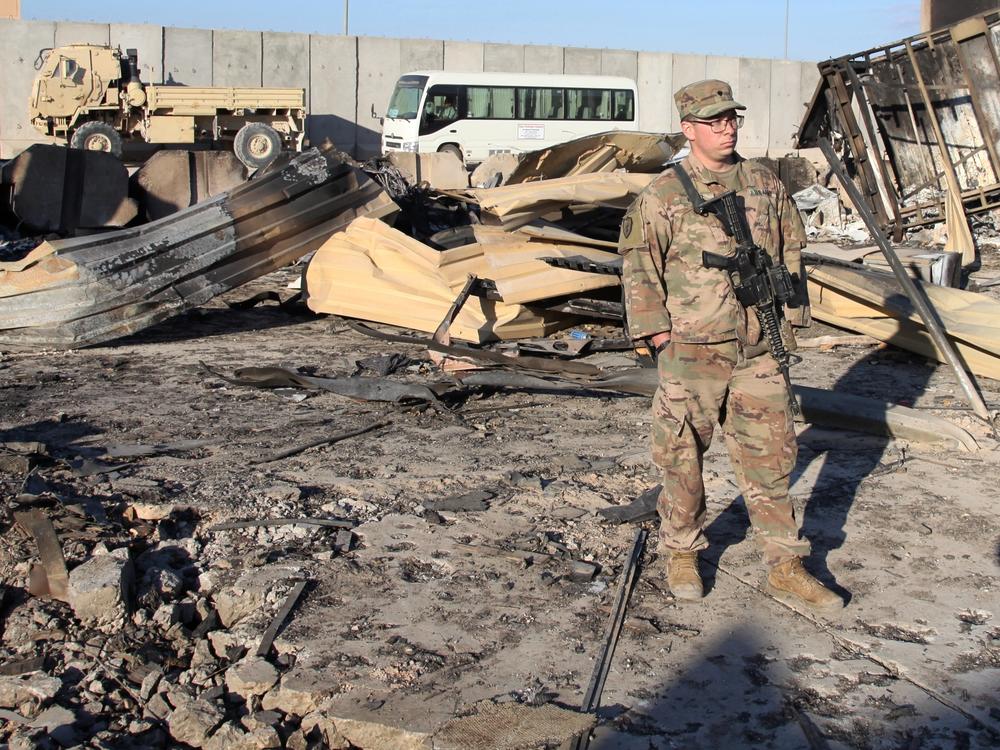 A U.S. soldier stands at a spot struck by Iranian missiles in January at Ain al-Asad air base in Iraq's Anbar province. The attack was in retaliation for the U.S. drone strike that killed Iranian Gen. Qassem Soleimani. The U.S. is drawing down 2,500 troops in Iraq and Afghanistan.