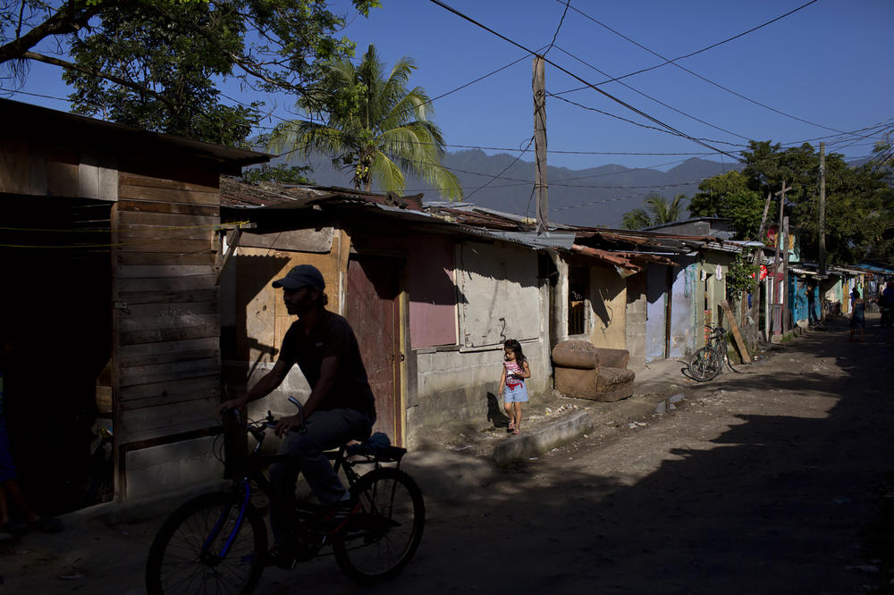 A young girl walks along the streets of a neighborhood in San Pedro Sula, Honduras, which has some of the highest homicide rates in the world due to violence from gangs and police.