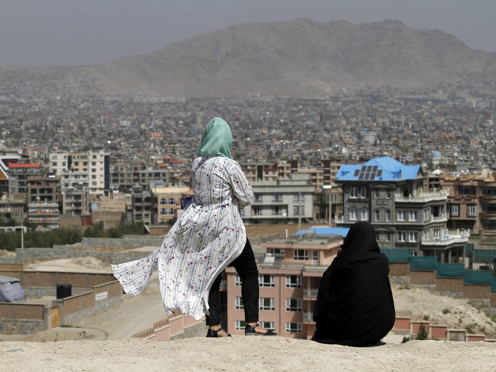 Afghan women look at the skyline of Kabul in September.